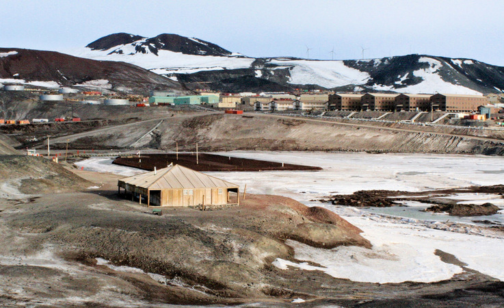 Die Discovery-Hütte auf Ross Island und im Hintergrund die US-amerikanische Basis McMurdo. Von