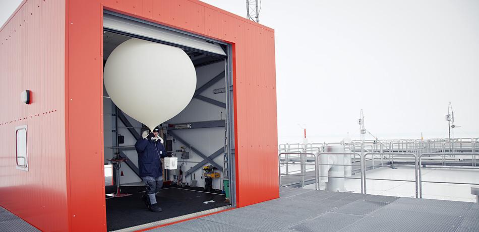 Mit dem Ballon und der Ozonsonde in der Hand geht der Meteorologe, hier Jölund Asseng aus dem Überwinterungsteam 2011, auf das Dach der Neumayer-Station.