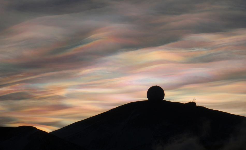 Ein herrlichen Sonnenaufgang begeisterte am 20. August Scott Base Angestellte, die zuletzt am 24. April die Sonne sahen. Polare Stratosphärenwolken (Perlmuttwolken) über der NASA Antenne bei  McMurdo Station, Antarktis (Foto: Alan Light)
