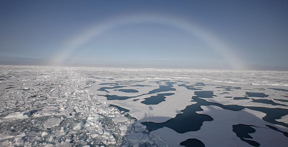 Schmelzwassertümpel am Nordpol im Sommer 2012. Darüber zeigt sich ein schöner Nebelbogen.